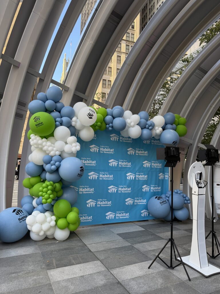 Colorful balloon archway with logo serves as a backdrop for an event